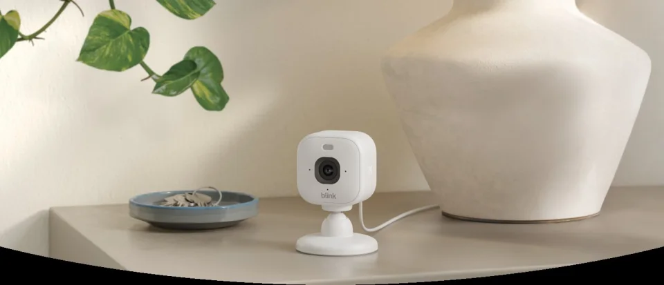 Blink Mini 2K+ sitting on a shelf in a living room