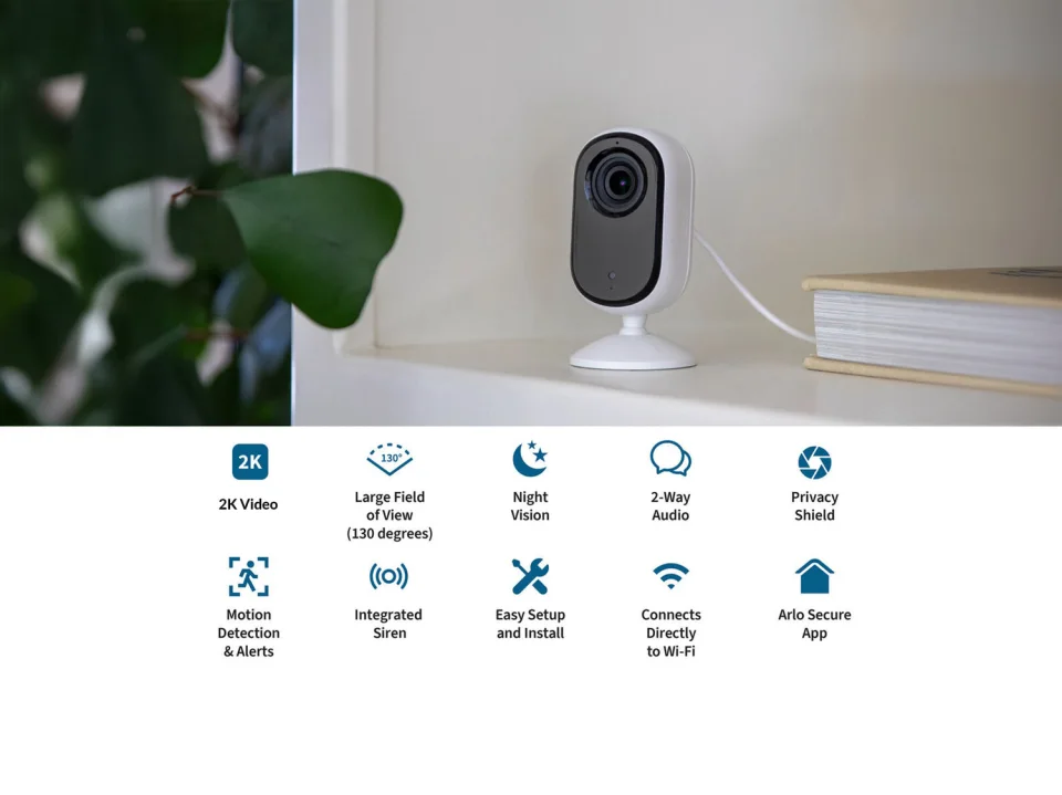 Arlo Essential Indoor Camera 2nd Gen on a shelf with official feature icons: night vision, 2-way audio, privacy shield, motion detection, integrated siren