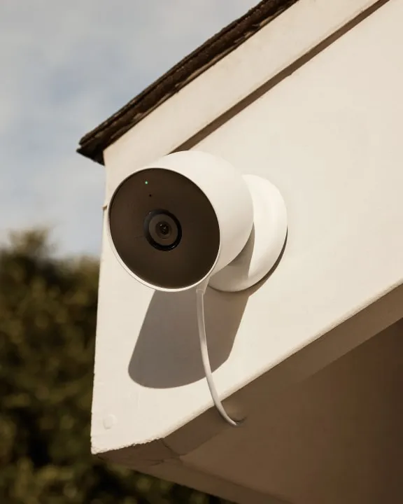 Close-up of the Google Nest Cam (battery) mounted on an outdoor wall, wired for continuous power