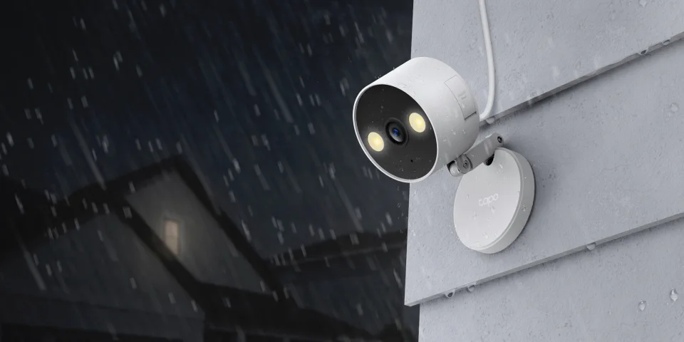 Tapo C120 mounted outdoors in the rain with spotlights on