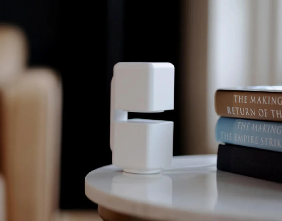 Wyze Cam Pan v4 on a side table next to books with its lens turned down and away in Privacy Mode