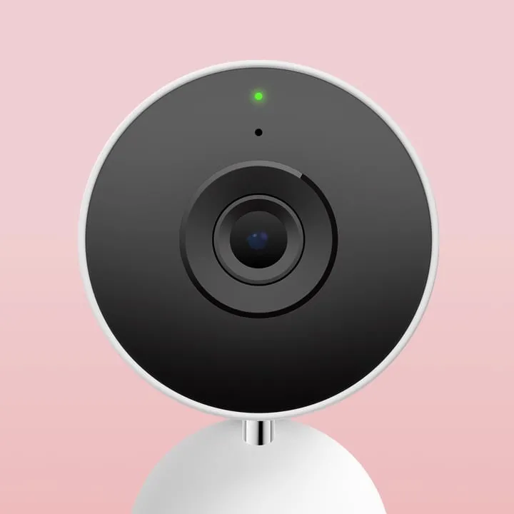 Close-up of the Google Nest Cam Indoor 3rd Gen lens and status light on a pink background