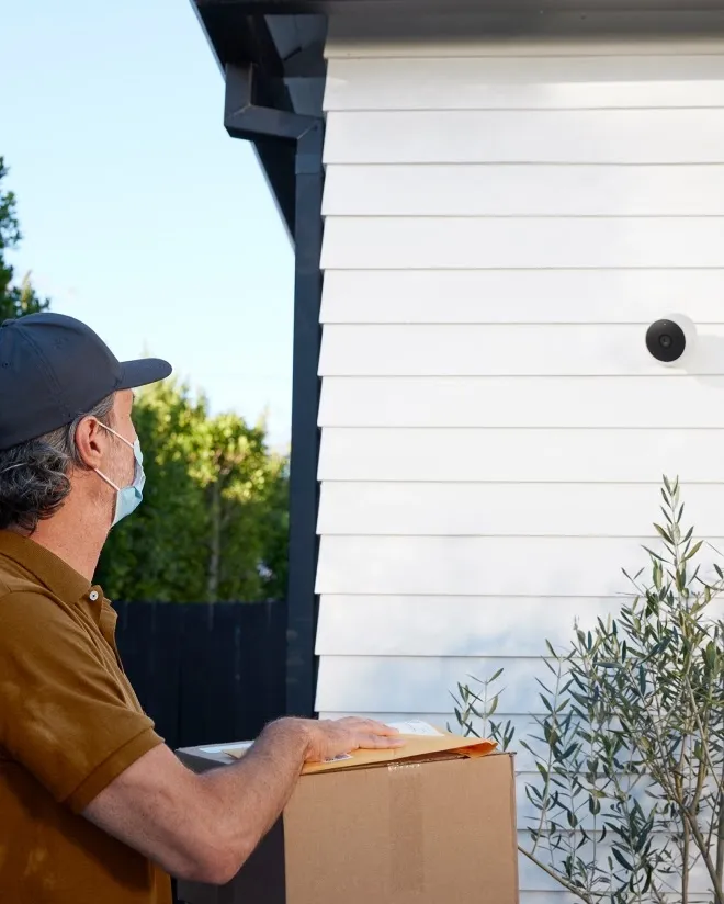 Google Nest Cam Battery mounted on exterior house siding watching a delivery at the front of the home